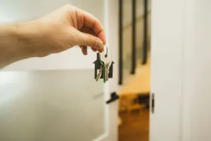 A hand holding a key to a door.
